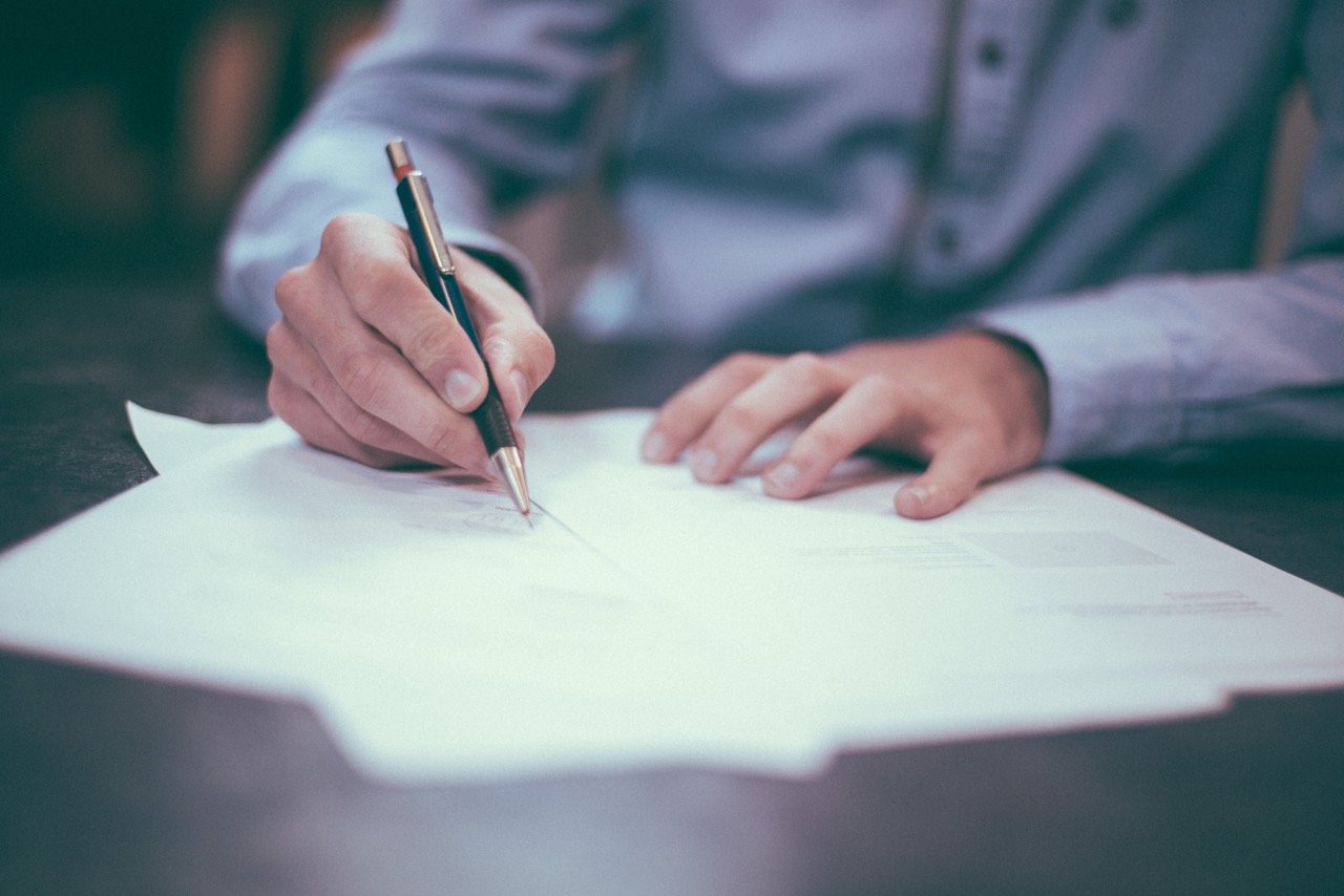 man signing background check paperwork